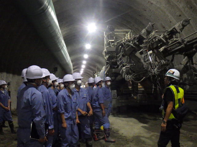 トンネル掘削機械（ドリルジャンボ）を間近で見学する盛岡工業高校の生徒たちの写真