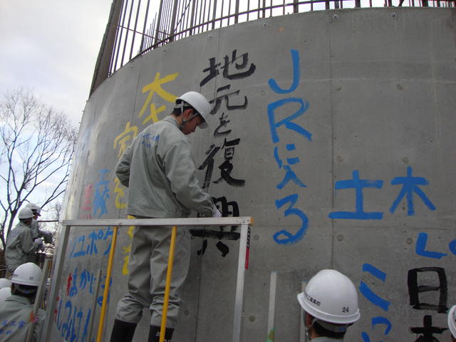 黒沢尻工業高校土木科2年生がP5橋脚基礎部にペイントしている写真