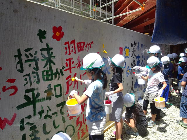 （仮称）新小谷木橋下部工（P3）の基礎部に「未来の羽田地区に託す想い」をペイントする児童の写真