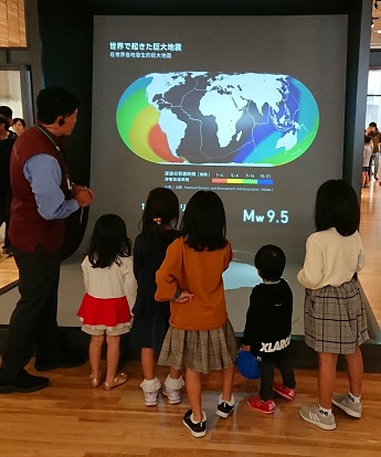東日本大震災津波伝承館で解説員の説明に聞き入る子どもたち
