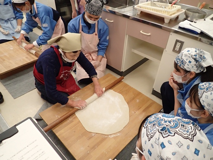 岩脇代表から生地の伸ばし方を学ぶ生徒