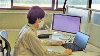研究室で作業中の小向技師の写真