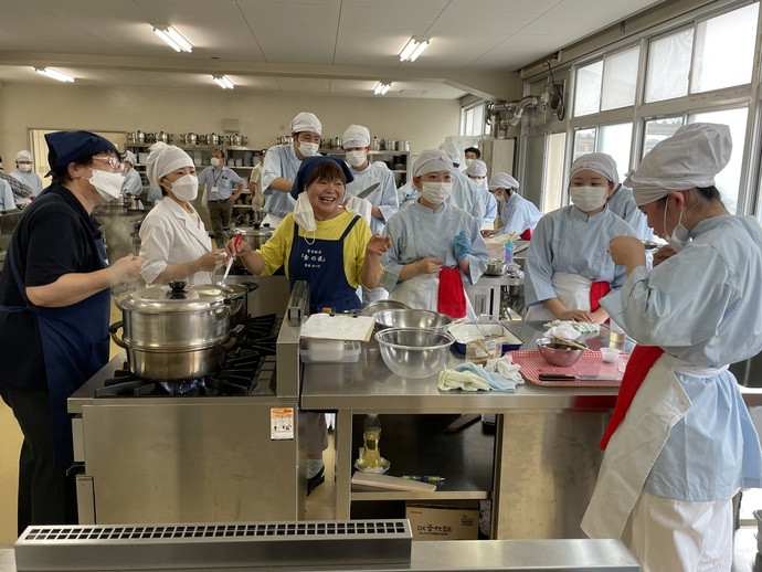 煮しめの味見をする食の匠と生徒たち