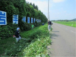 市道沿いの草刈り作業の様子の写真